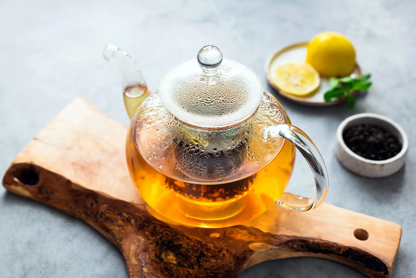 Jarra de té de verde con limón y clavos.