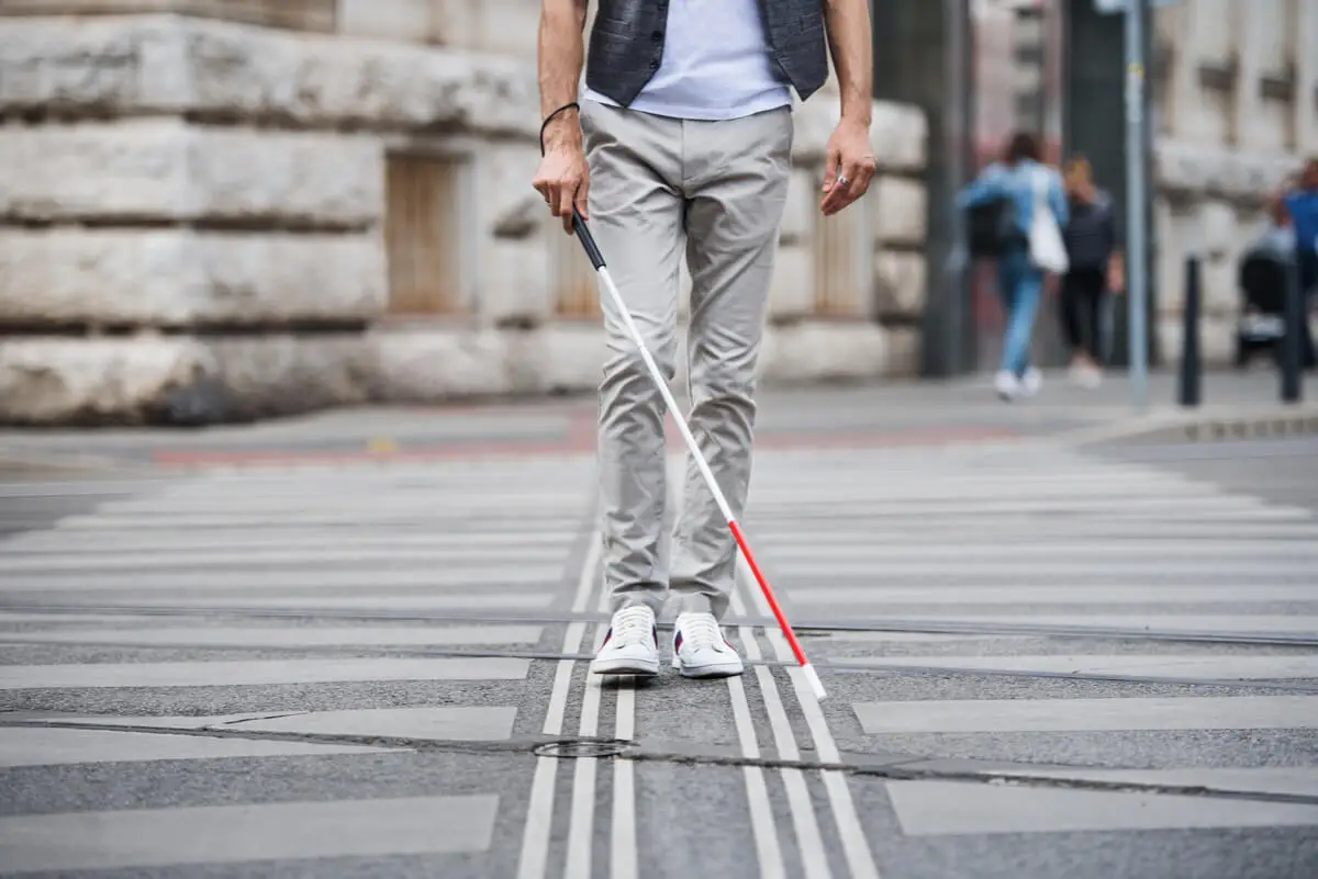 Hombre ciego con bastón blanco.