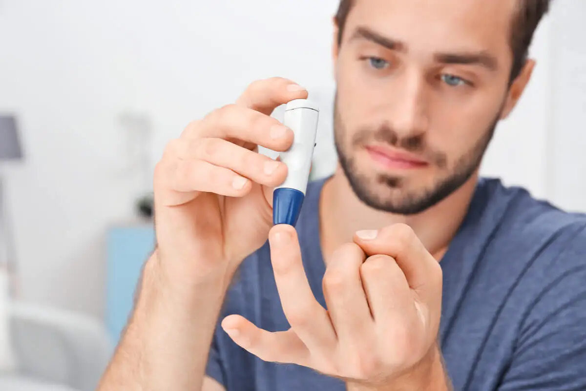 Hombre con diabetes mide su glucemia.