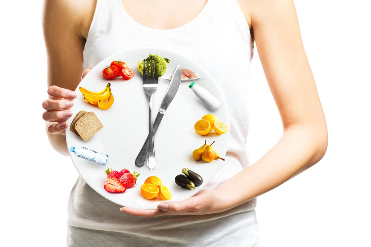 Mujer sostiene reloj de alimentos.