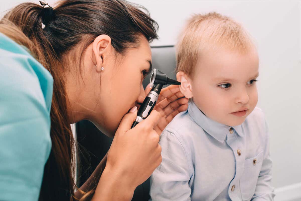 Pediatra revisa oído de un niño.