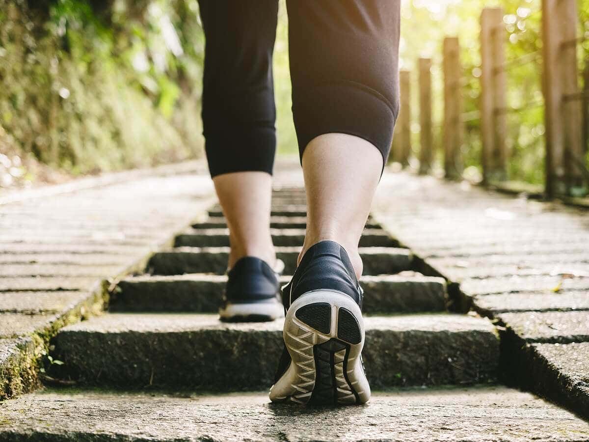 Trotz Krankheit trainieren - Frau läuft Treppen hinauf