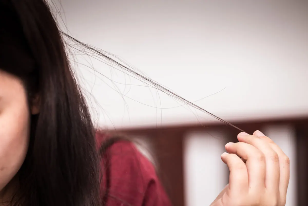 Mujer estira su cabello.