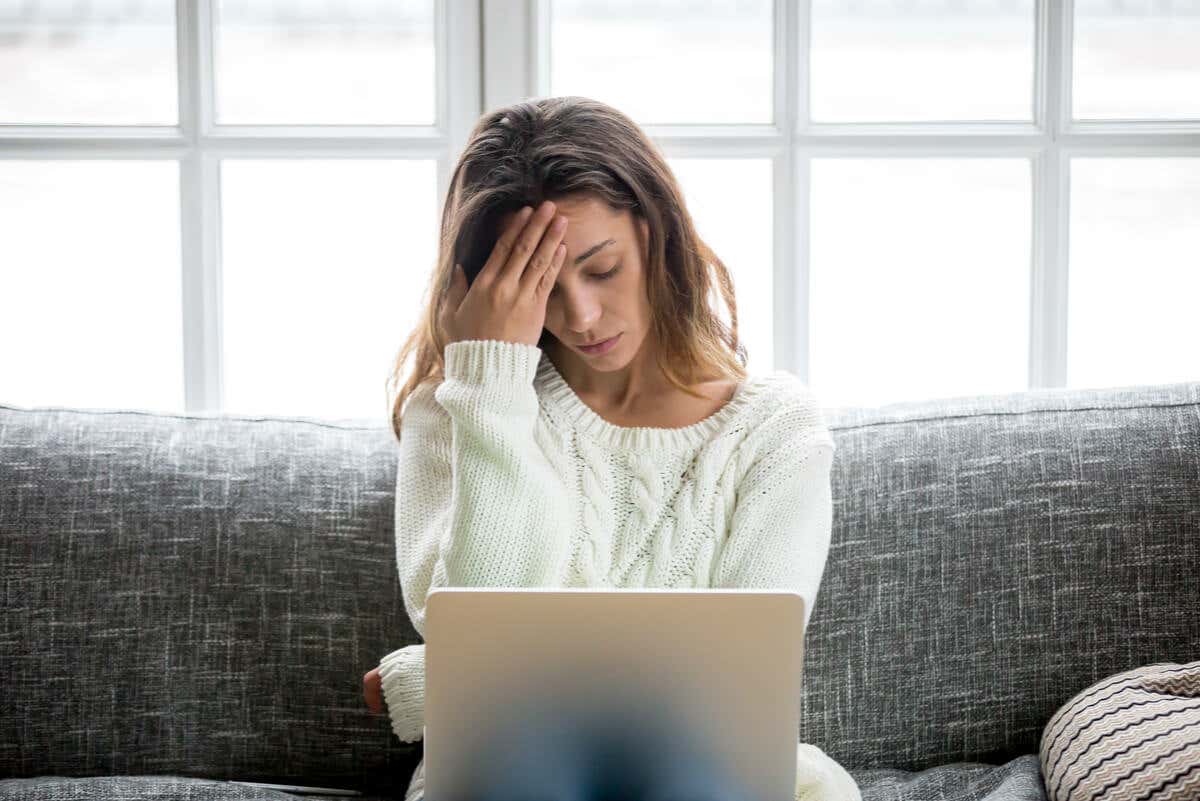 Mujer estresada frente a computadora.