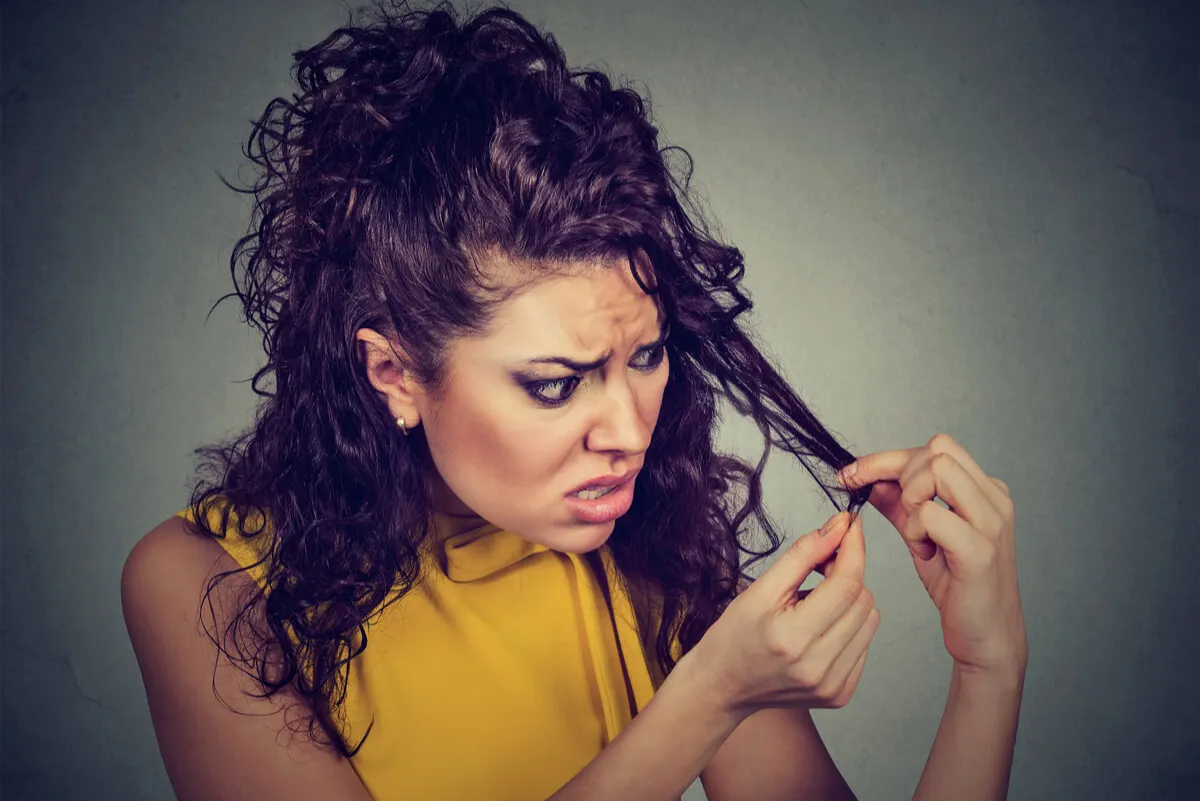 Observación del cabello por parte de una mujer.