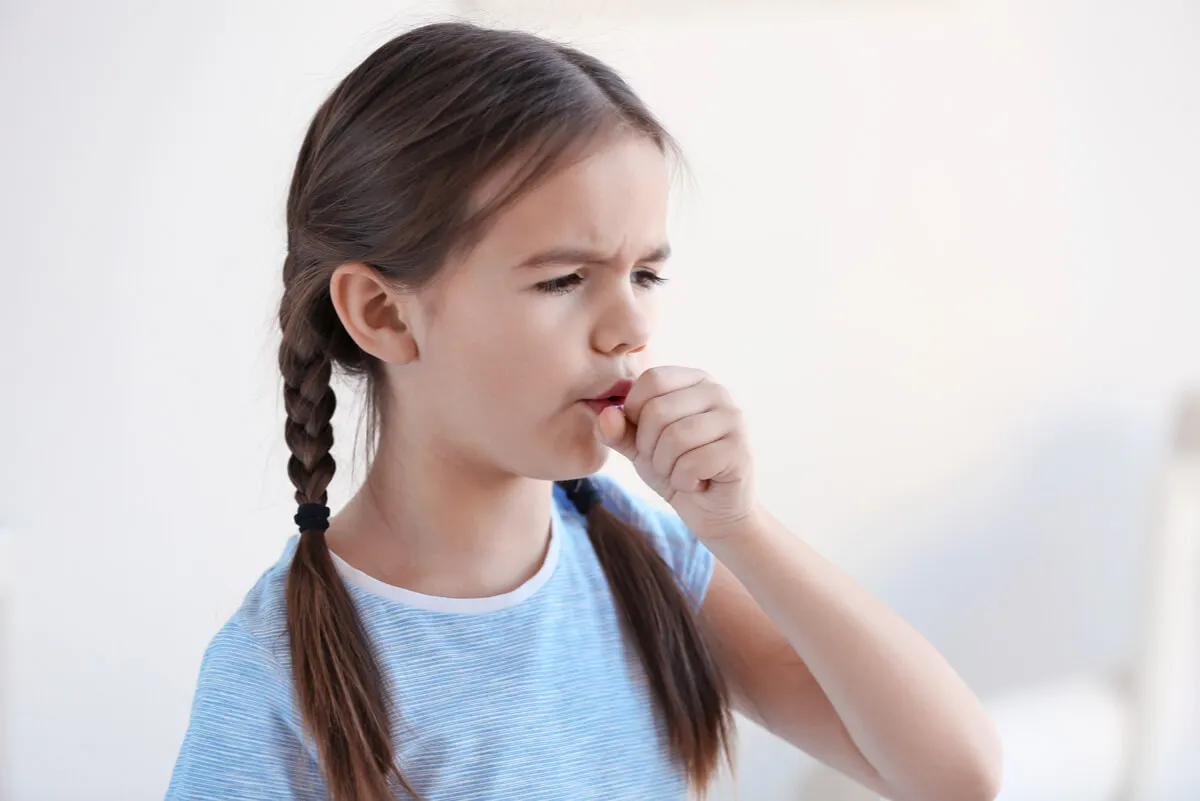 Niña tose con infección respiratoria.