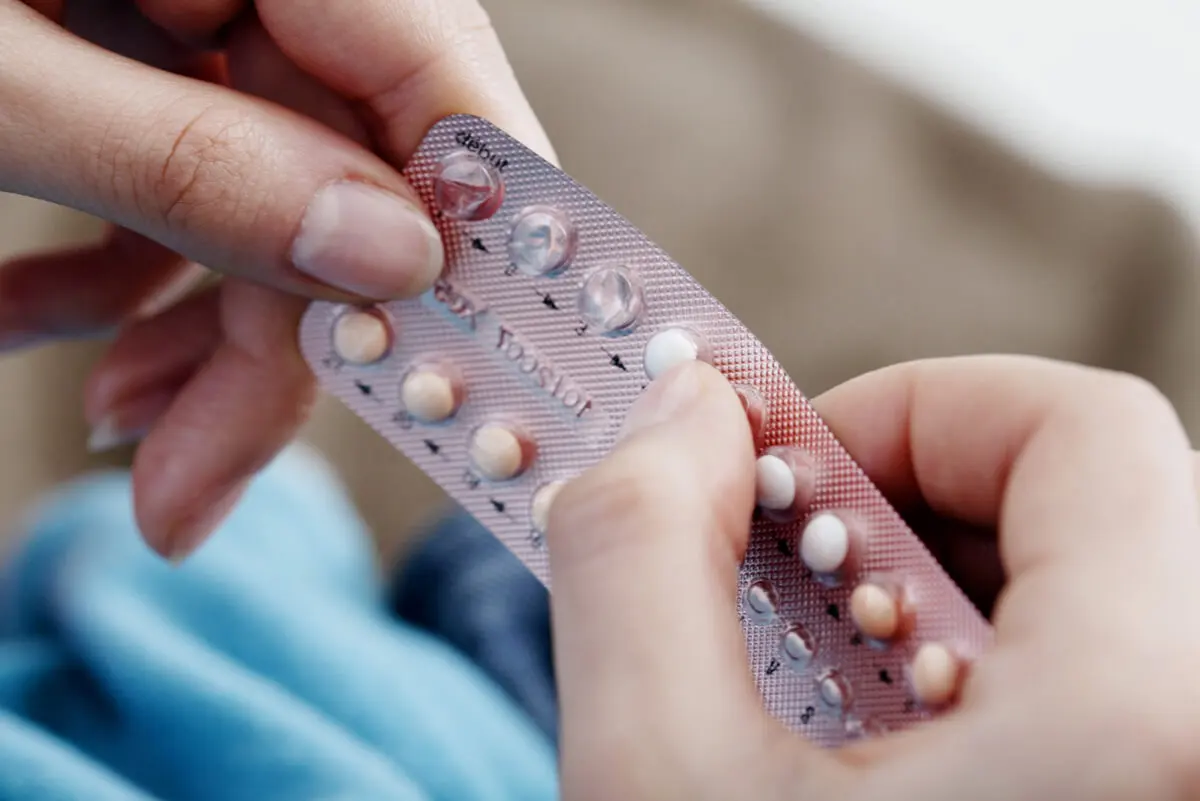 Pastillas anticonceptivas en las manos.
