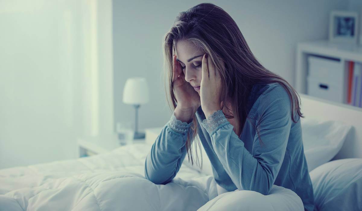 Mujer con insomnio por fibromialgia.