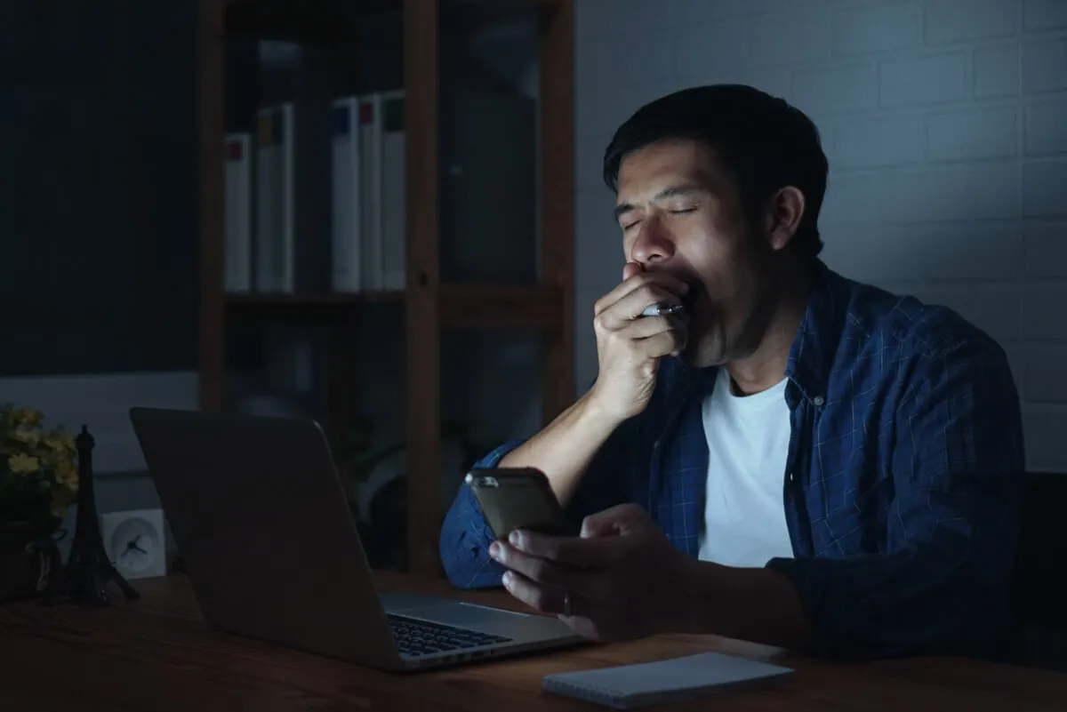 Hombre con sueño por quedar despierto a la noche.