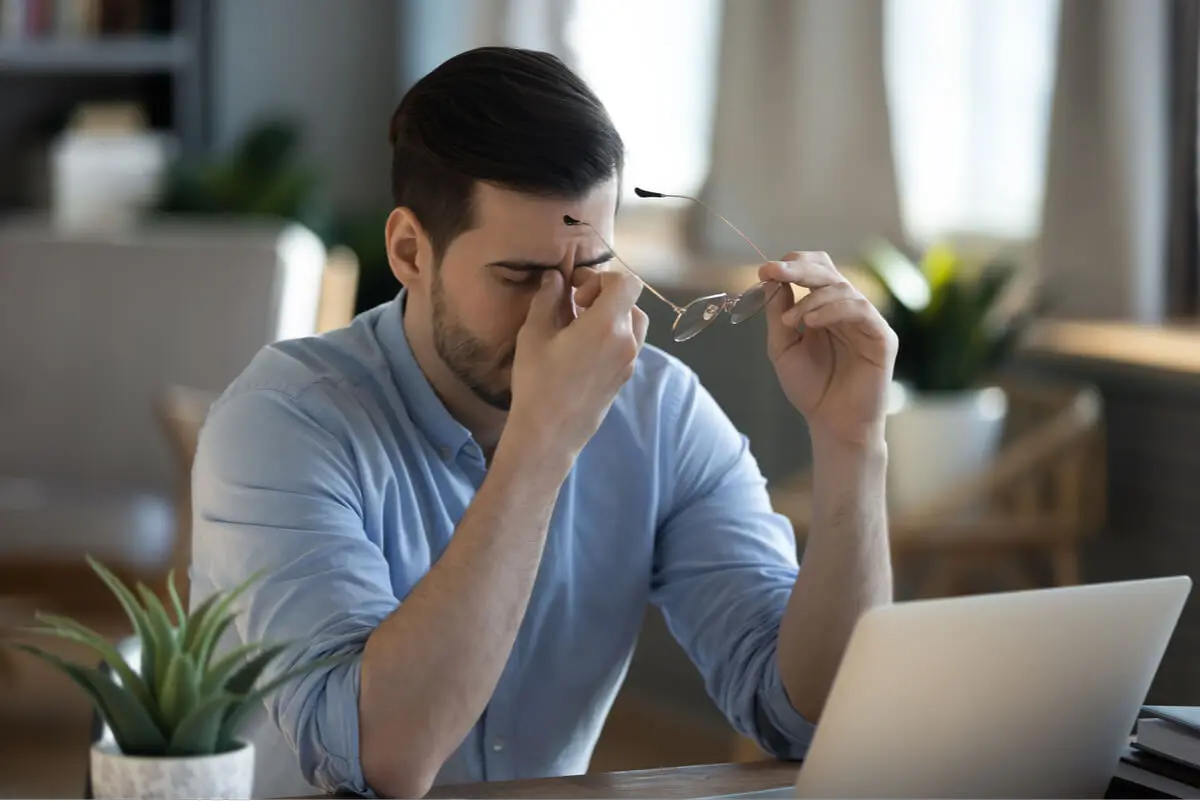 Cyber-Sickness - Mann vor dem Laptop reibt sich die Augen