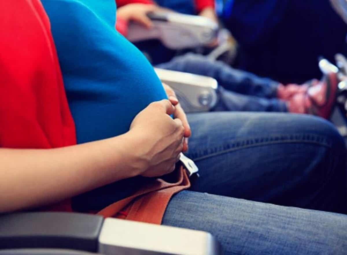 Mujer viajando en avión durante el embarazo.