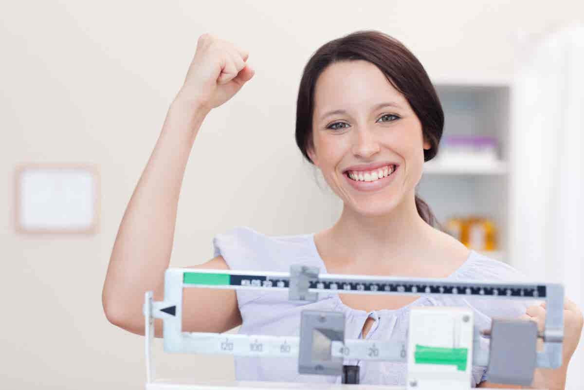 Mujer festeja el éxito de una dieta para bajar de peso.