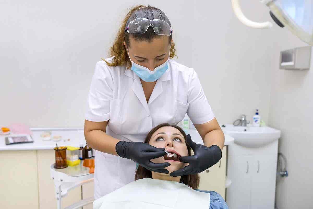 Odontóloga coloca piercing dental.