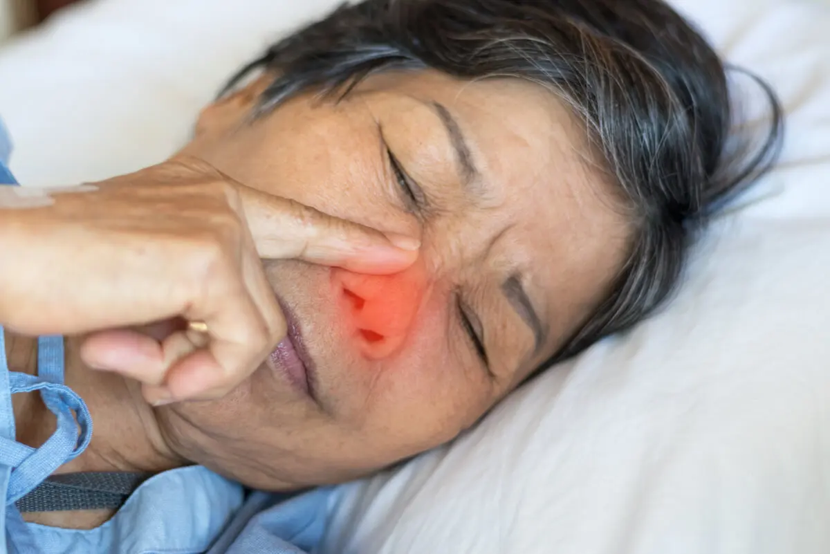 Mujer toca su nariz de dormida para comer mocos.
