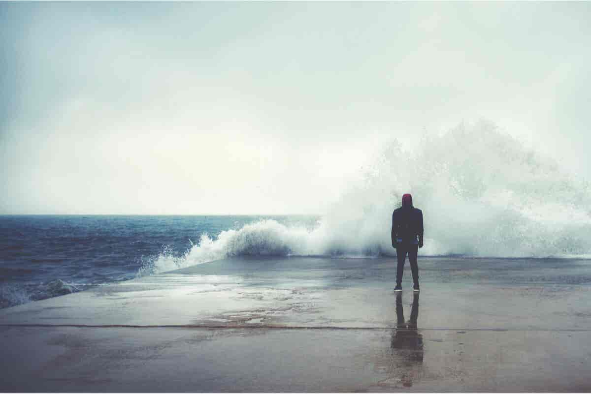 Persona frente al océano con miedo.