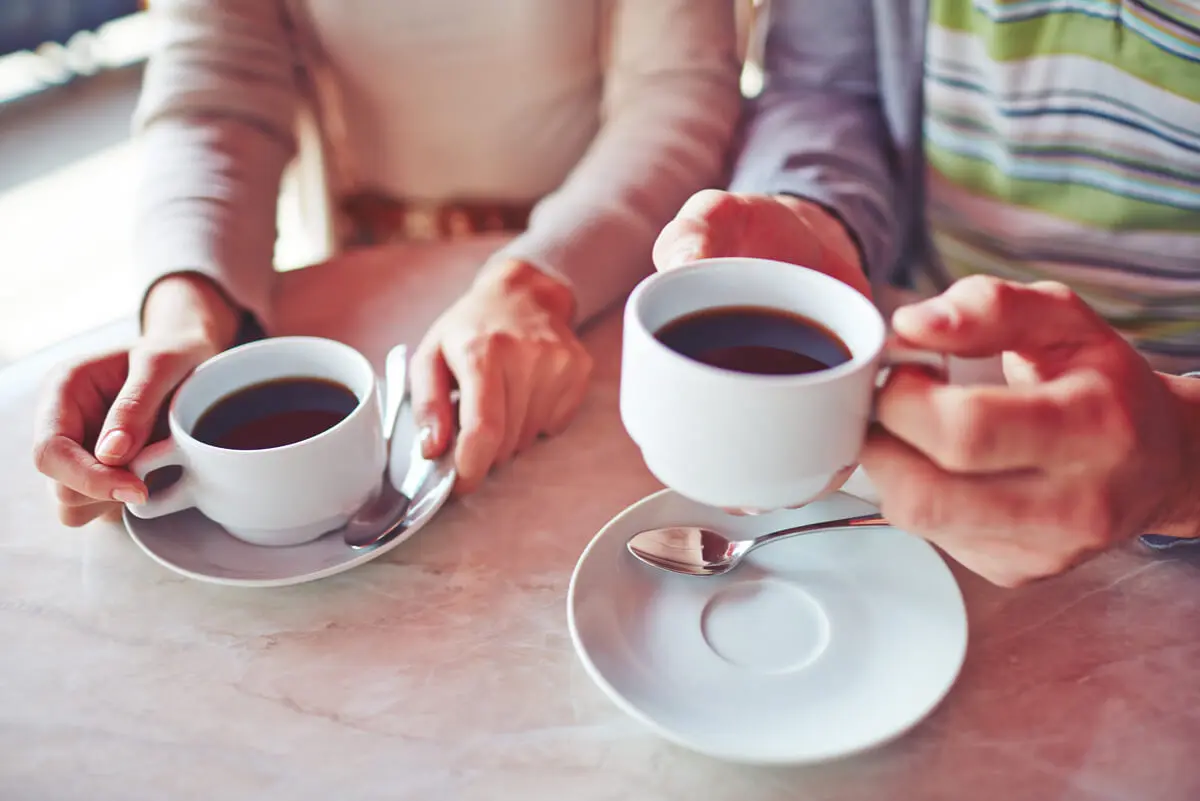 Tazas de café y manos.