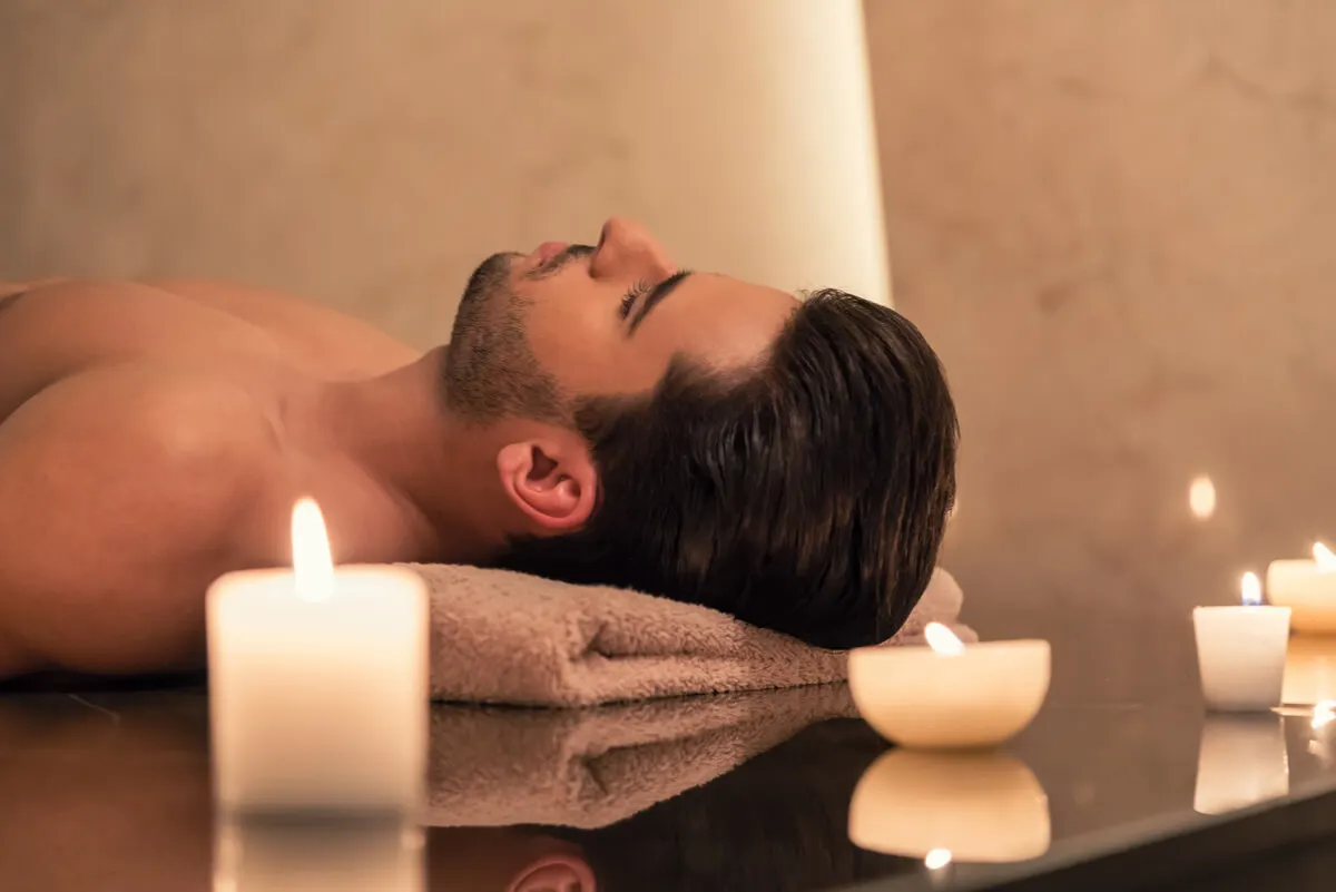 Hombre utiliza velas aromáticas para relajarse.