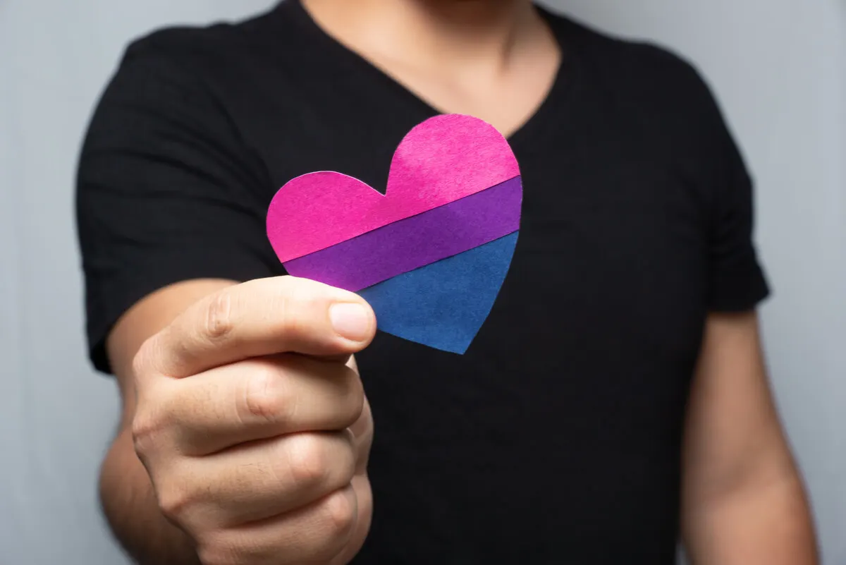 Hombre con símbolo de orgullo bisexual.