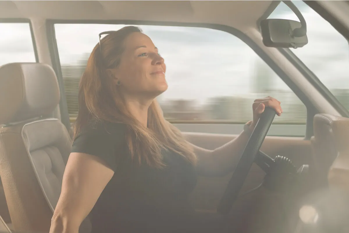 Mujer revisa los retrovisores con riesgo de accidente en su auto.
