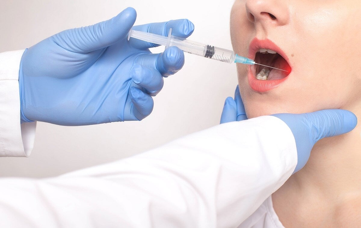 Schwarze Flecken auf dem Zahnfleisch - Patient bekommt eine Spritze