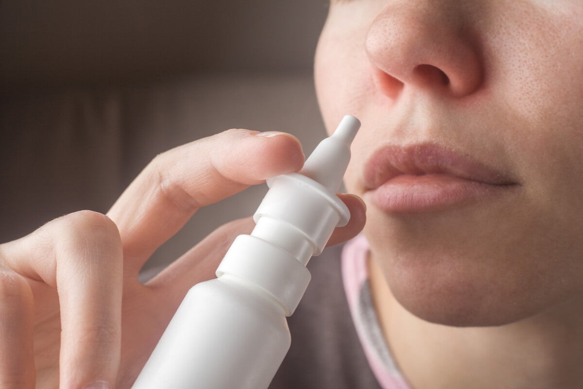 Nicht-allergische Rhinitis - Frau benutzt Nasenspray