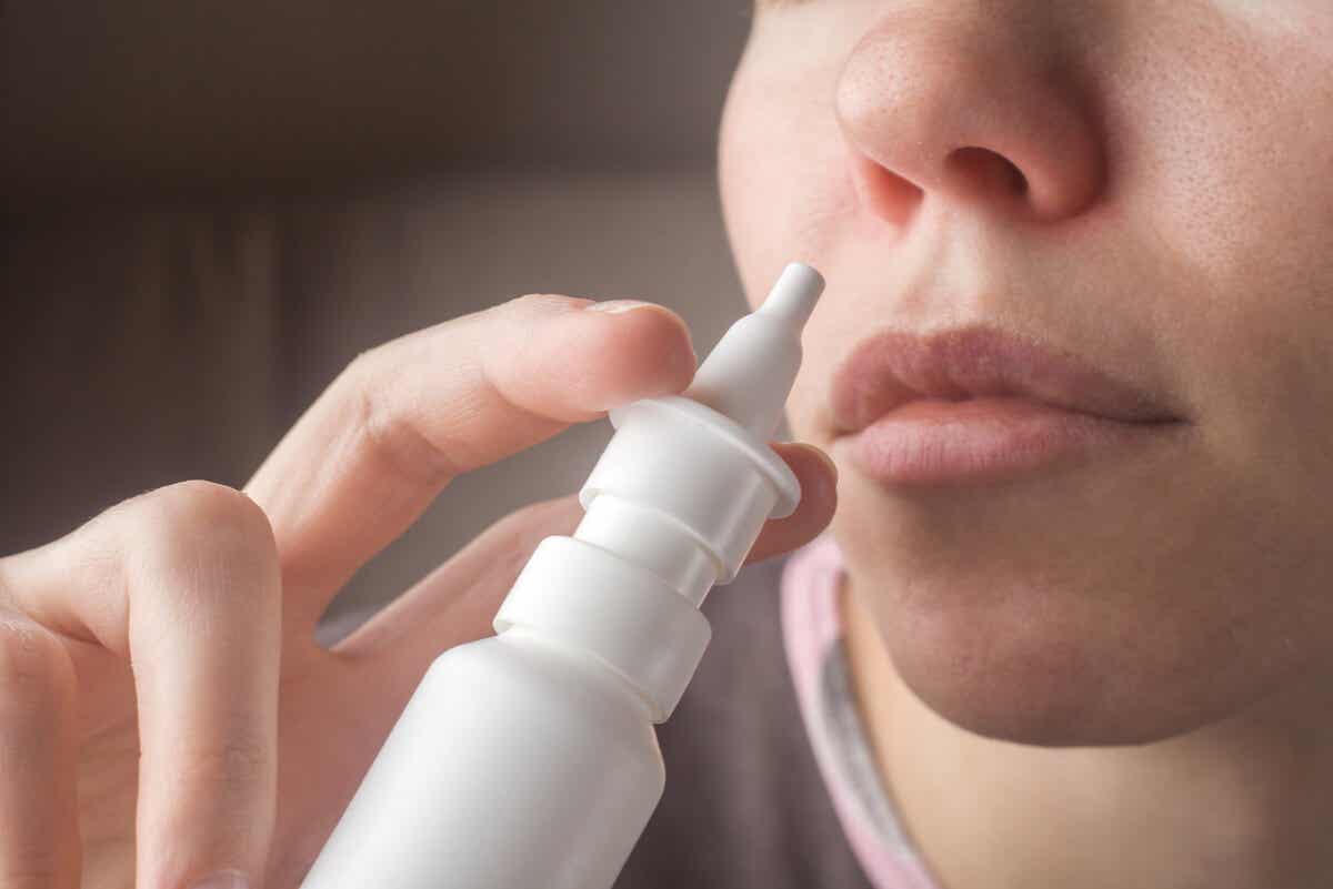 Nicht-allergische Rhinitis - Frau benutzt Nasenspray