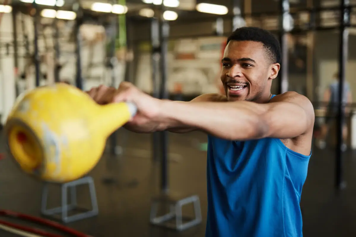 Kettlebell swing realizado por un hombre en el gimnasio.