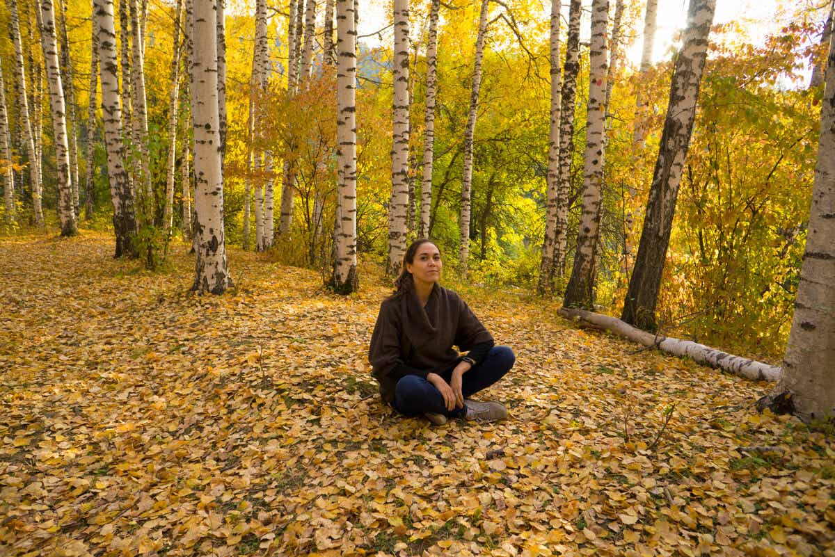 Shinrin Yoku - Frau sitzt auf dem Waldboden