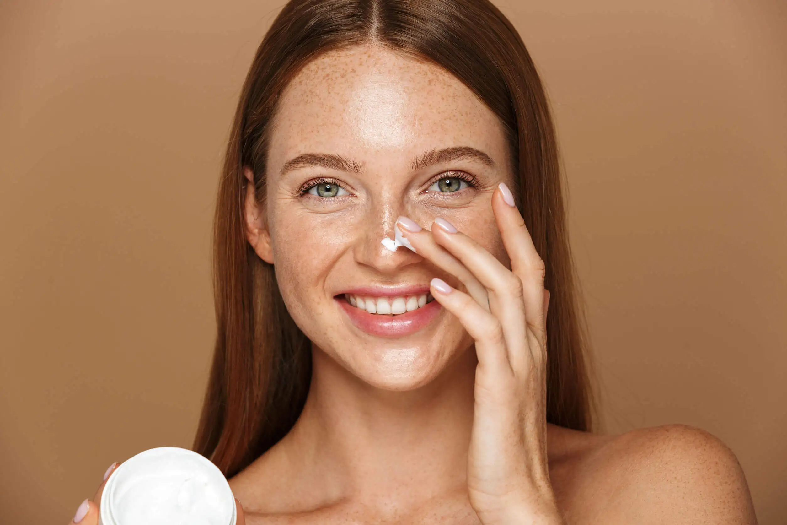 Vrouw smeert BB cream op haar gezicht