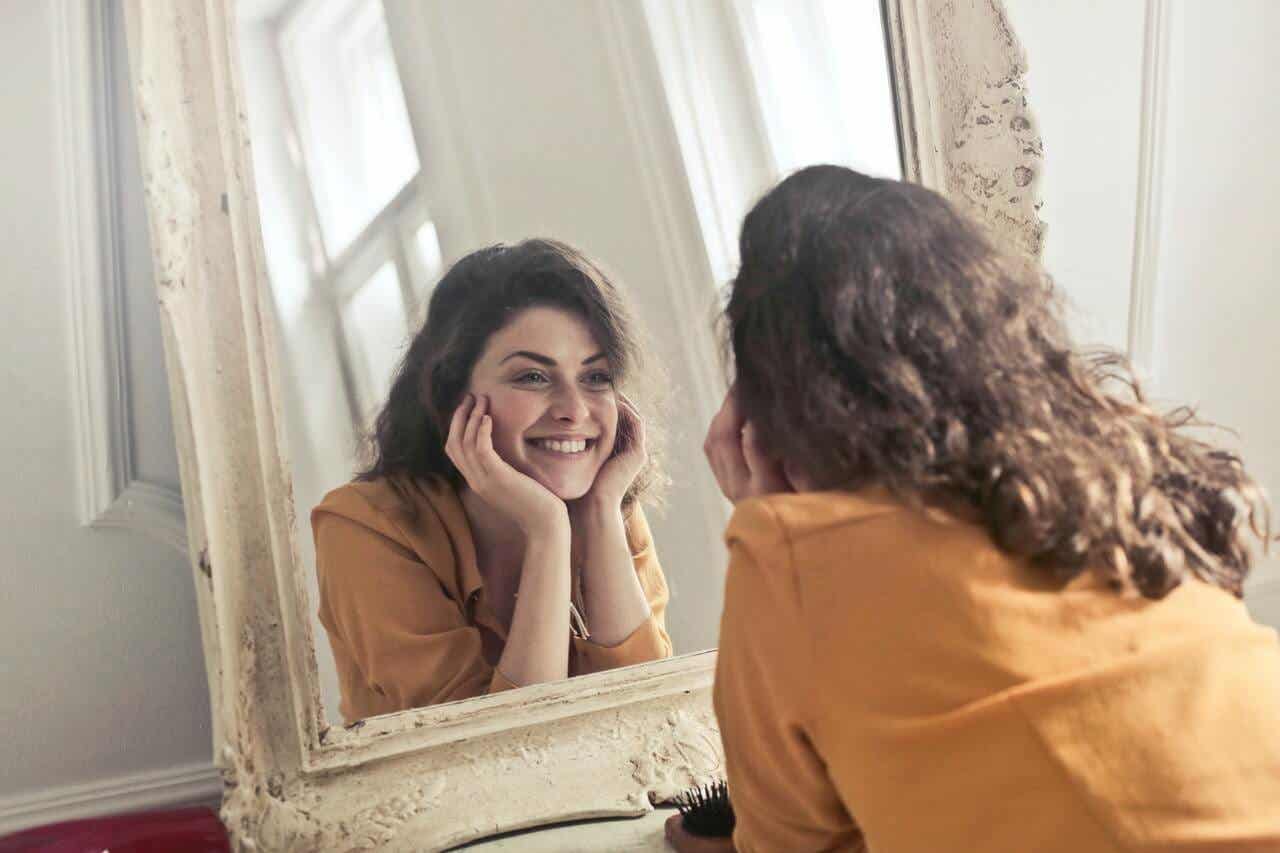 Mujer expresa gratitud frente a un espejo.