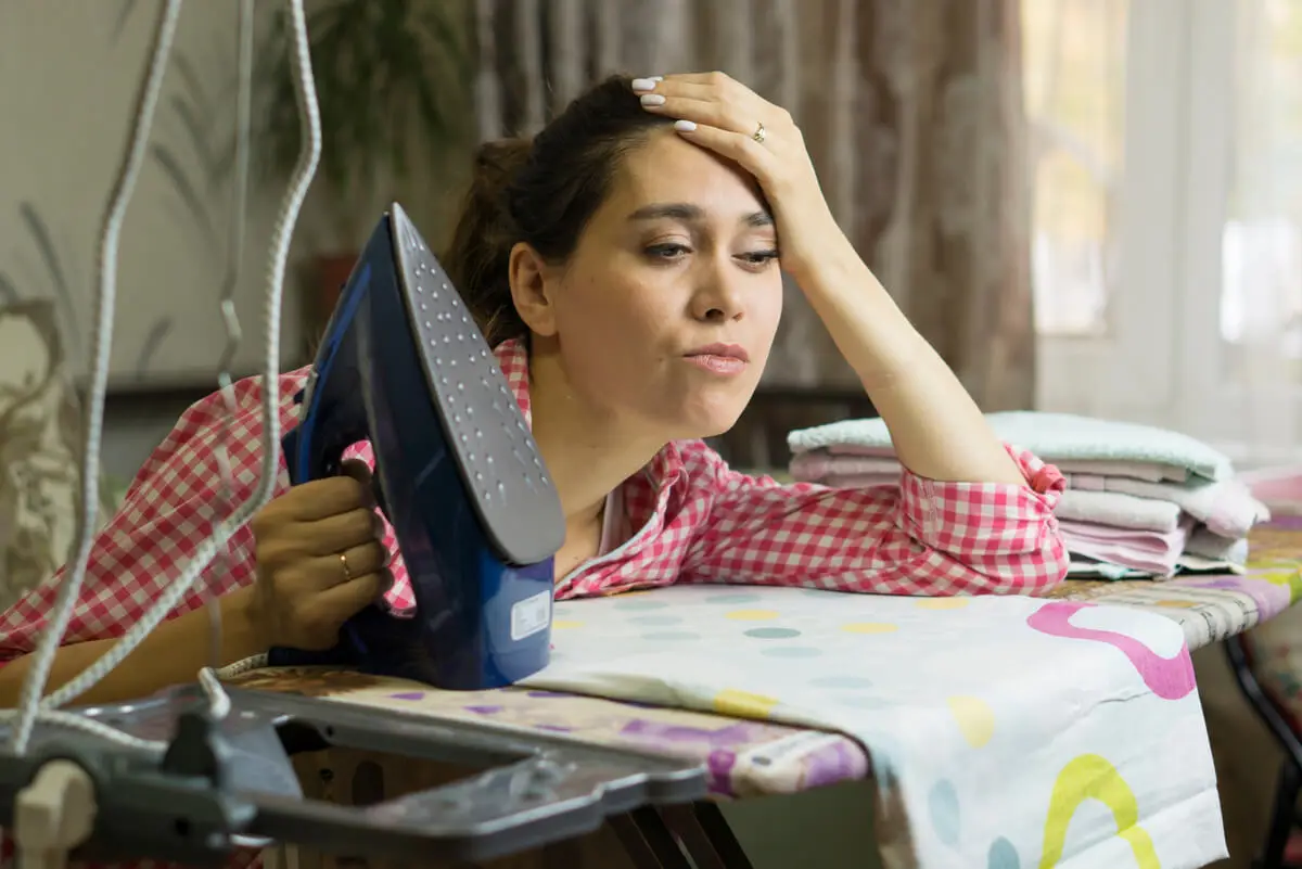Femme inquiète car le fer utilise beaucoup d'énergie.