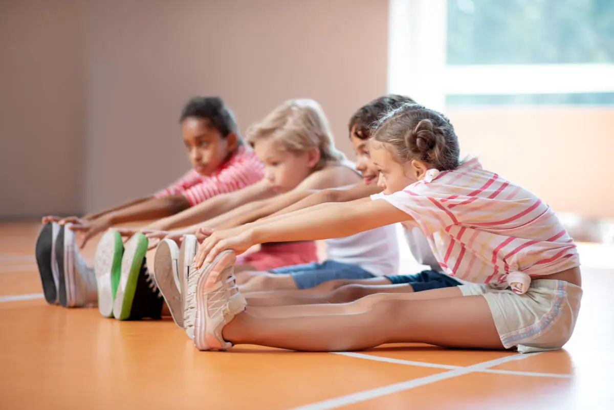 Estiramientos para evitar lesiones por exceso de actividad física en niños.