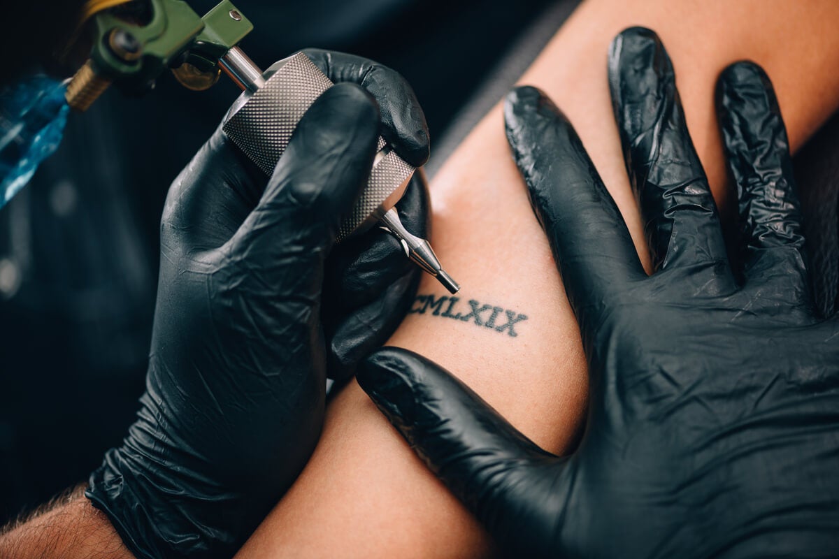 Un tatoueur en train de tatouer. 