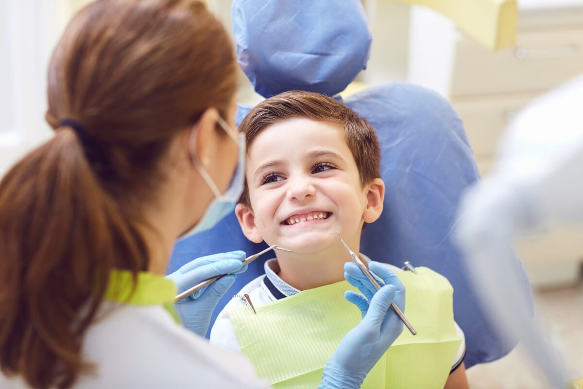 Dentista verificando a boca de uma criança.