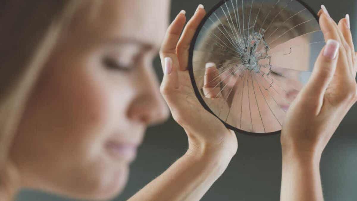 Blickkontakt - Frau sieht nicht in einen zerbrochenen Spiegel