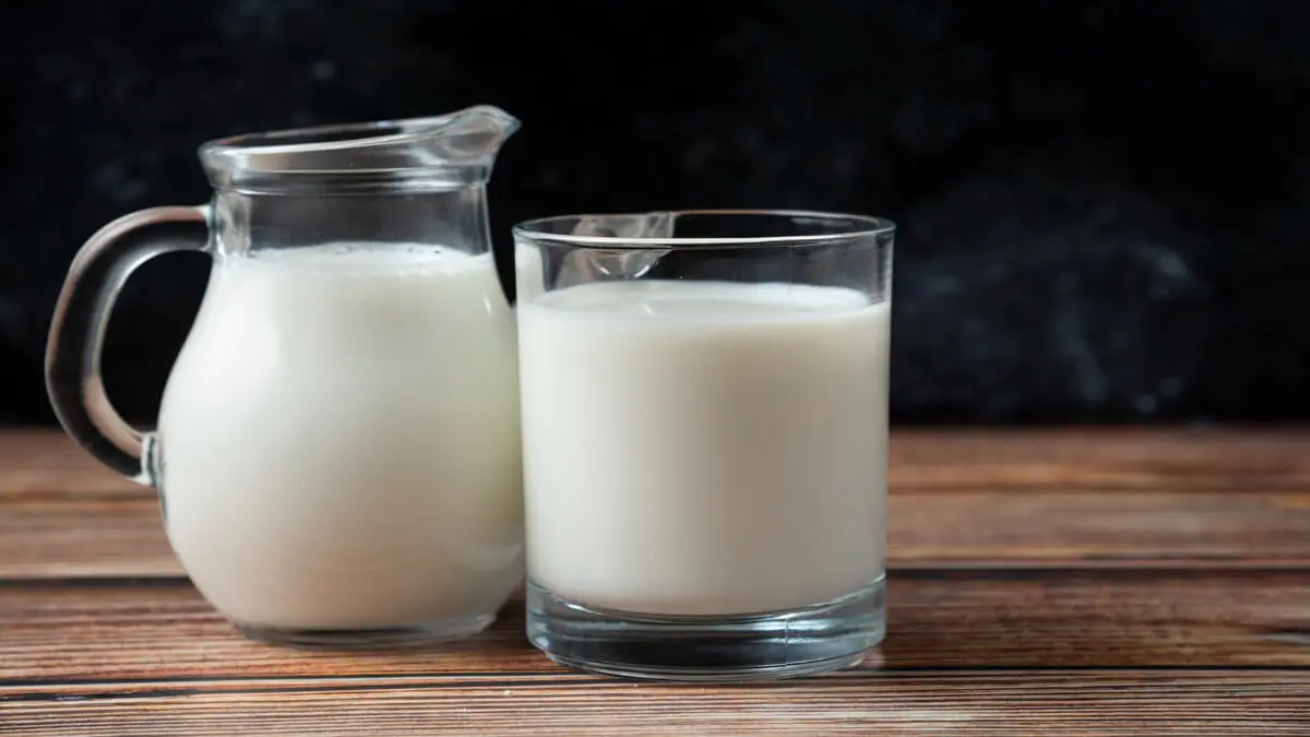 Una jarra y un vaso con leche.