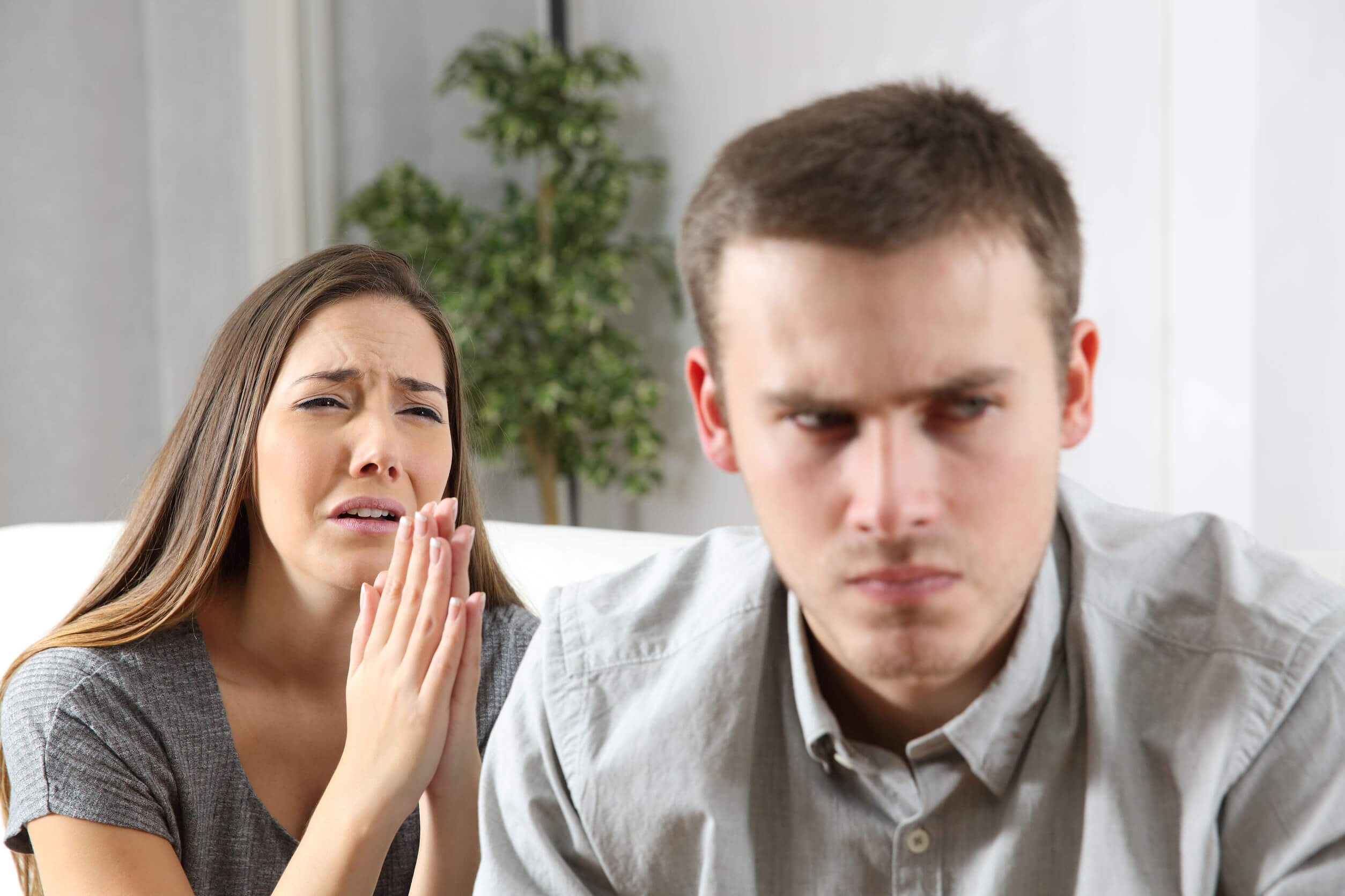 Folgen von Untreue - weinende Frau appelliert an ihren Partner