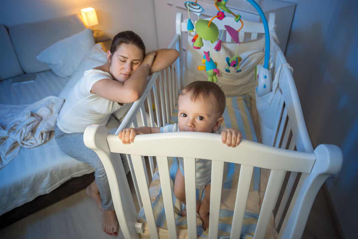 Madre dormida cuida un bebé de noche.