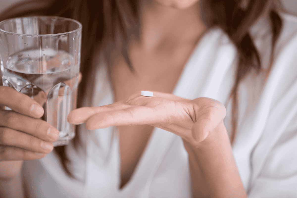 Bioidentische Hormone - Frau mit Tablette in der Hand