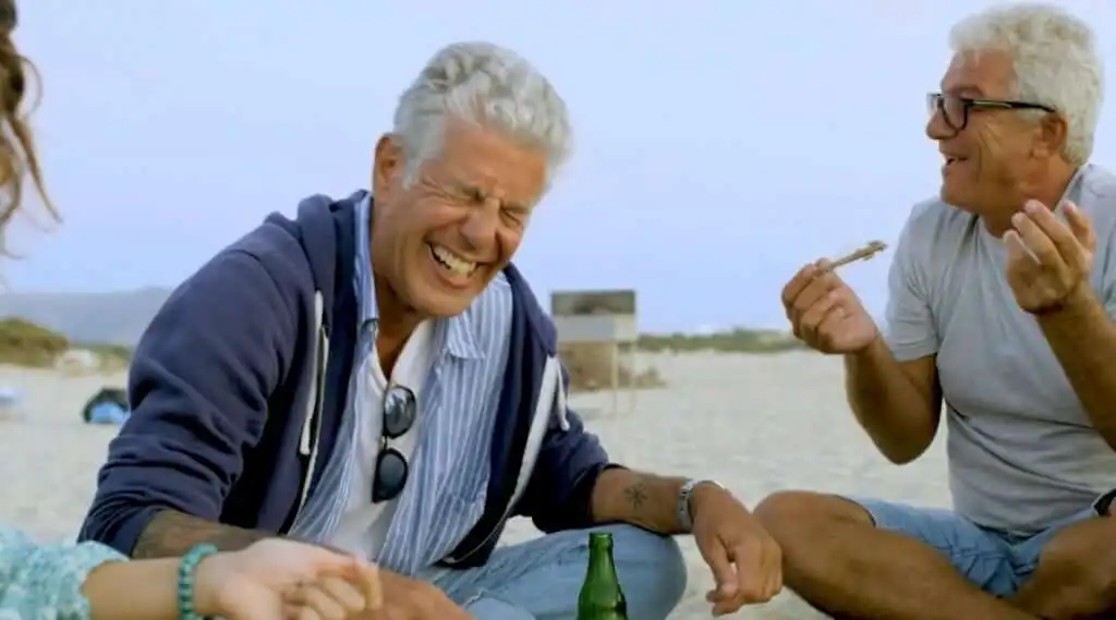 Bourdain disfrutando con otras personas en un viaje