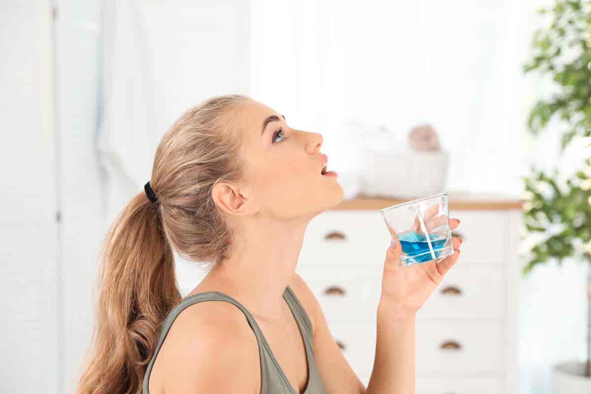 Zungenreinigung - Frau benutzt Mundwasser
