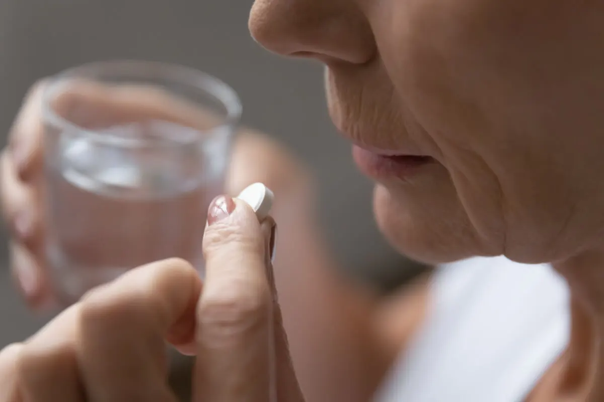 Vrouw slikt een aspirine
