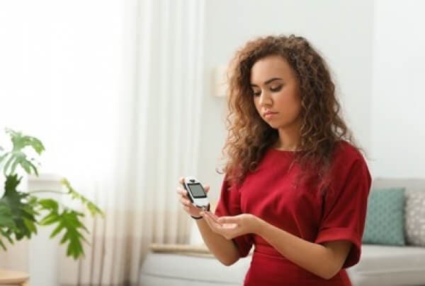 Donna con misuratore di glicemia.