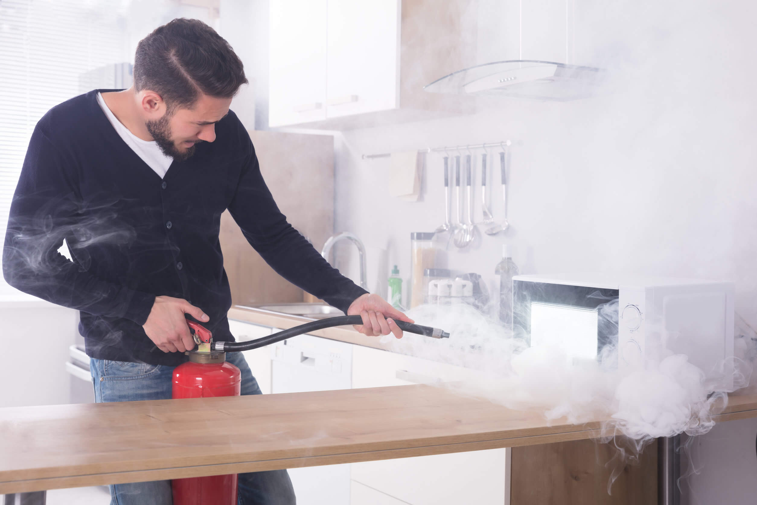 Gefahren in der Küche - Mann mit mit Feuerlöscher
