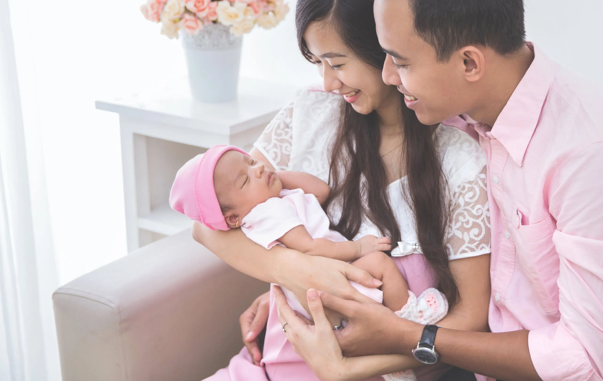 Bébé très demandé dans les bras de ses parents.