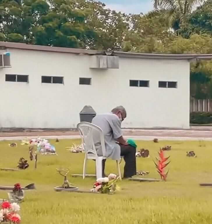 Le grand-père à côté de la tombe de sa bien-aimée