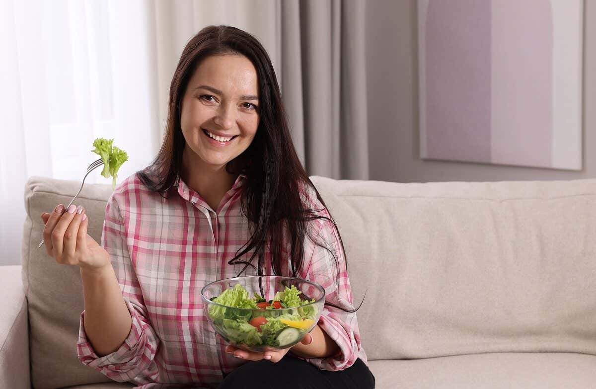 elinde salatasıyla koltukta oturan mutlu kadın