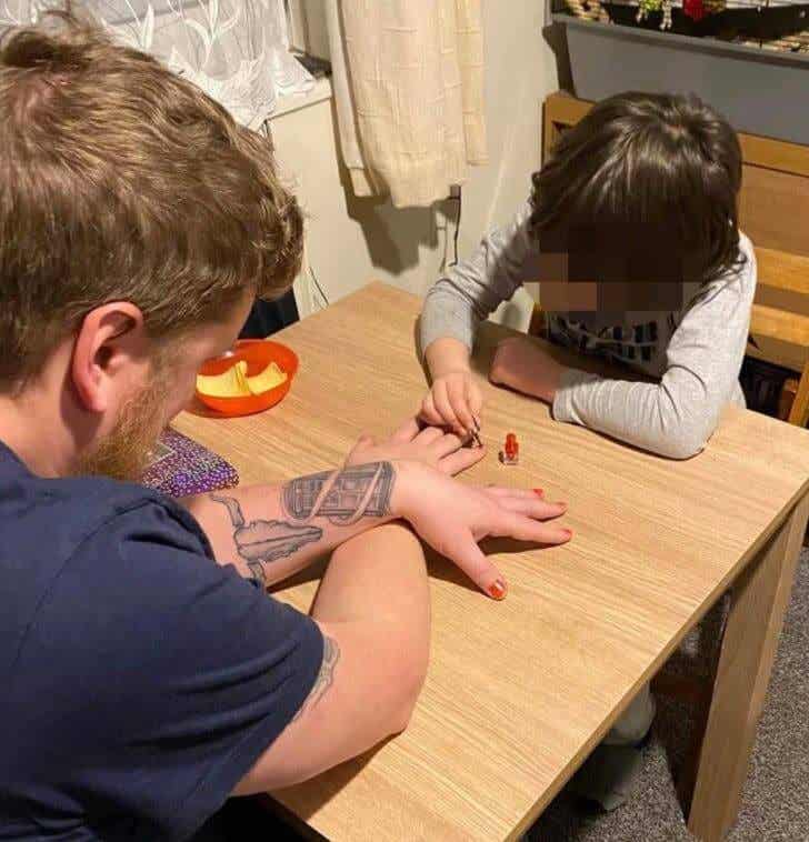 Niño pintándole las uñas a su padrastro 