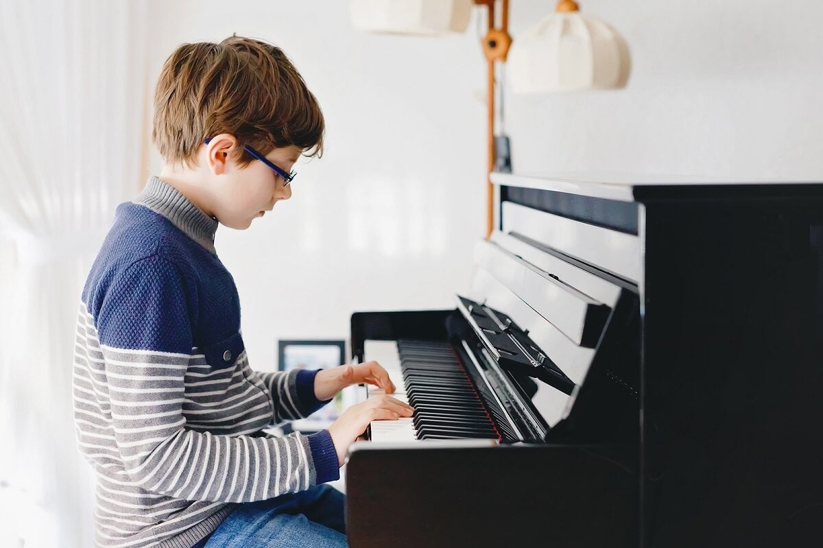 Een jongen die op een piano speelt