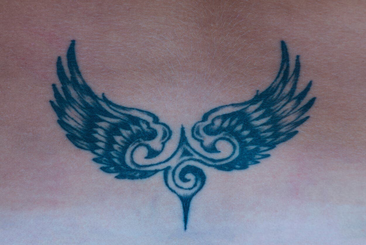 Tatuaje simbólico de águila y alas.